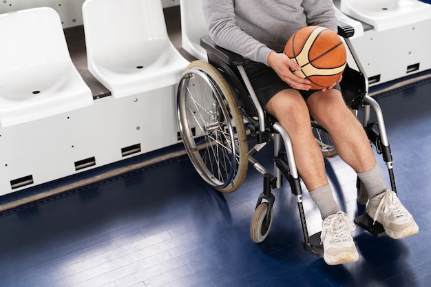 Foto feche a pessoa na cadeira de rodas segurando a bola