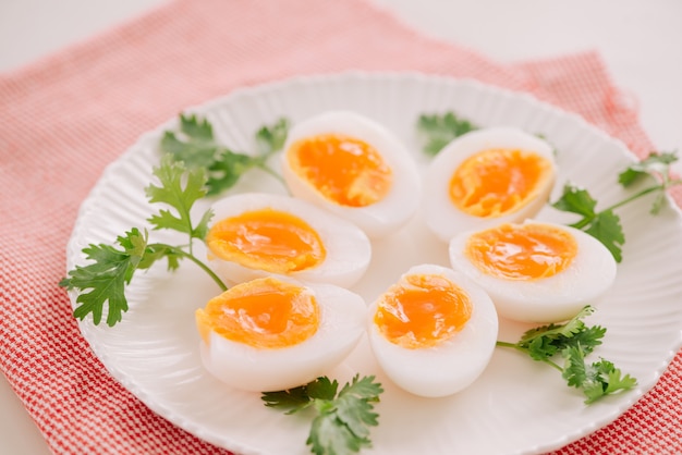 Feche a porção de ovo de pato fervido médio e macio no prato branco