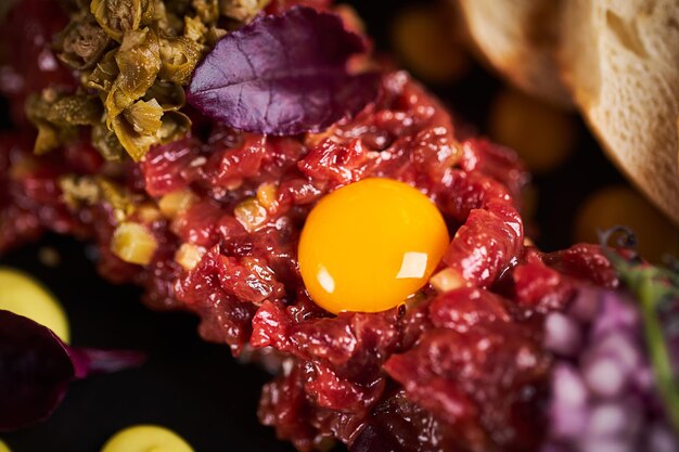 Feche a visão macro do tártaro de carne com ovo no restaurante foto de alta qualidade