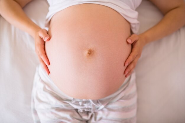 Feche a vista da barriga da mulher grávida