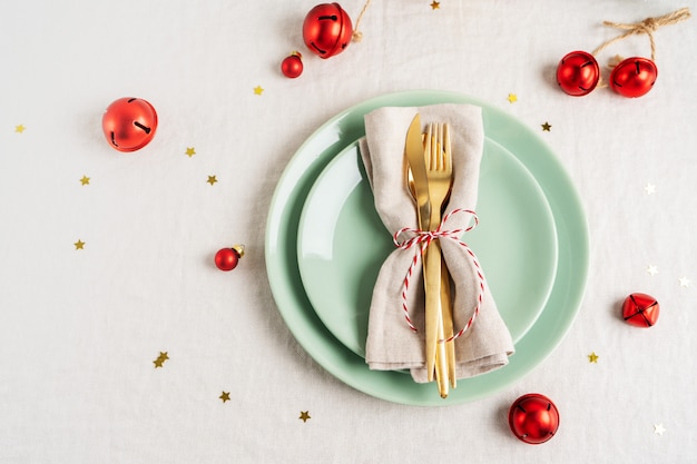 Feche a vista de talheres de ouro em guardanapo leve para configuração de mesa de natal.