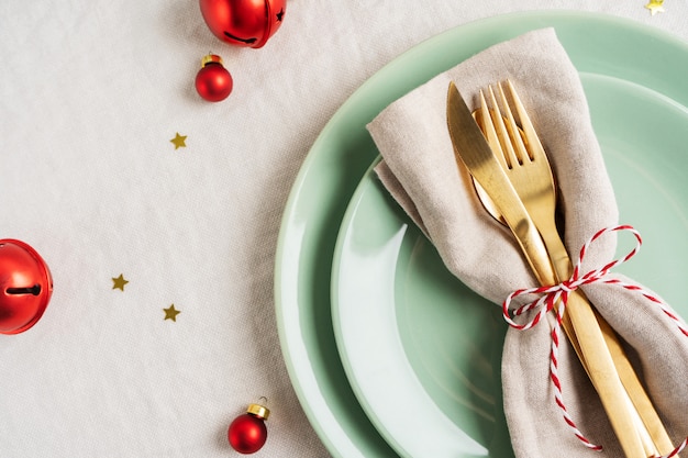 Feche a vista de talheres de ouro em guardanapo leve para configuração de mesa de Natal.