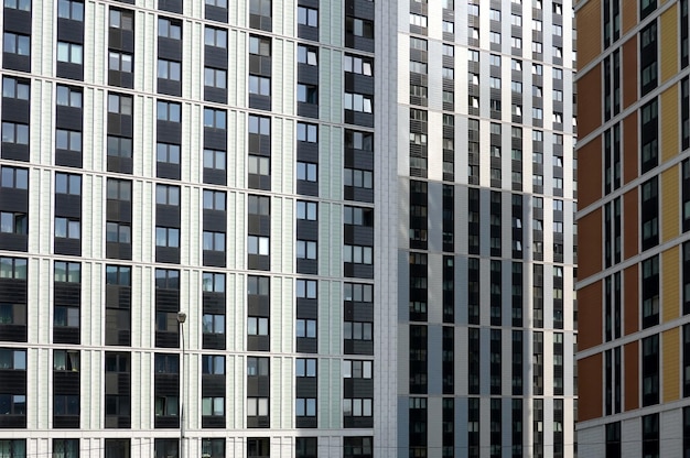 Feche a vista frontal das fachadas de edifícios modernos densos com muitas janelas no centro da cidade