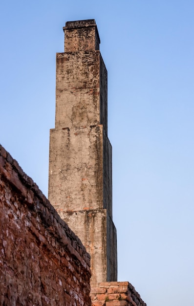 Feche a vista inferior de um antigo forno de tijolos abandonado ou chaminé sob o céu azul da noite