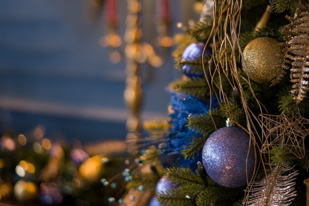 Feche acima da árvore de Natal decorada com enfeites azuis e luzes, decorações de Natal