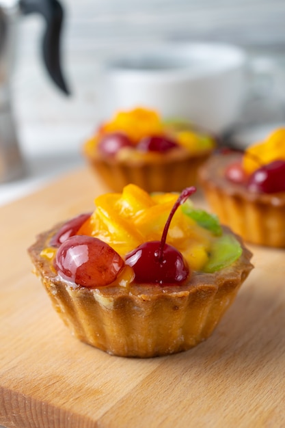 Feche acima da foto da mini galdéria da fruta com cereja e quivi alaranjados.