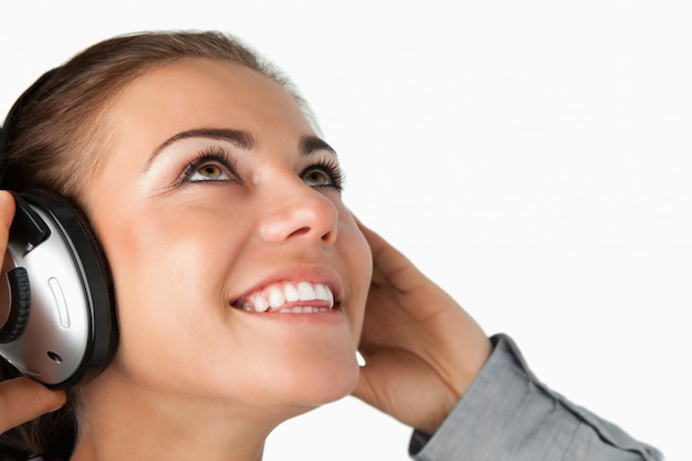 Feche acima da jovem empresária ouvindo música