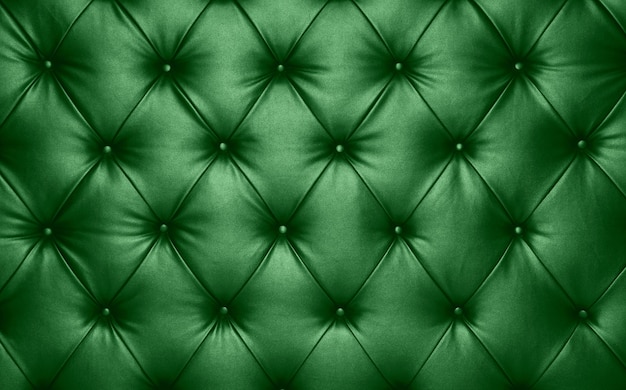 Feche acima da textura do fundo de couro genuíno capitone verde escuro, estofamento de móveis em estilo retrô Chesterfield com padrão de diamante profundo e botões