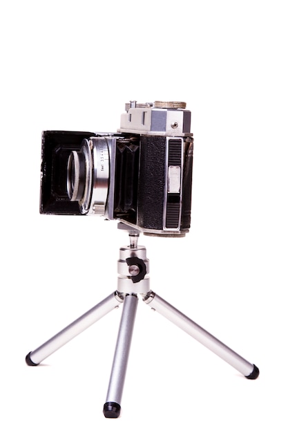 Feche acima da vista de uma câmera fotográfica do vintage retro isolada em um fundo branco.