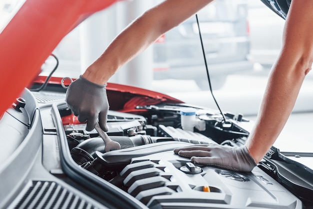 Feche acima da vista do homem de uniforme que trabalha com automóvel quebrado. Concepção de serviço automóvel