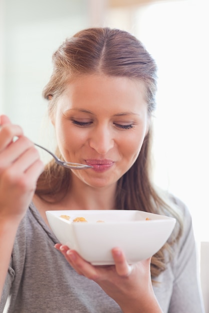 Feche acima das cerejas femininas comendo