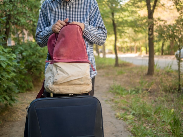 Foto feche acima das mãos da pessoa procure coisas na mochila ao ar livre