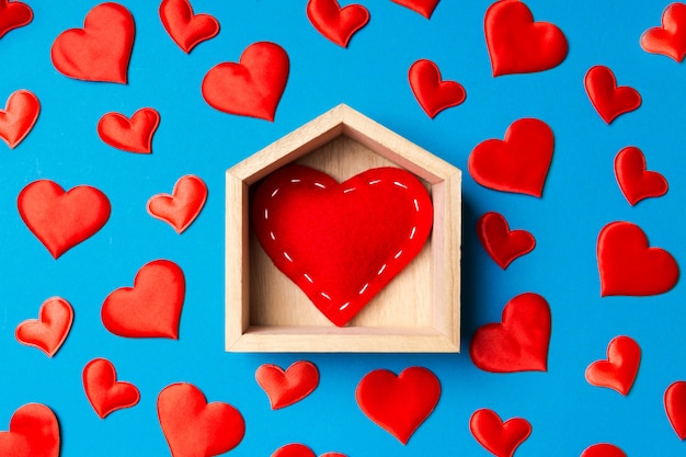 Feche acima do coração vermelho em uma casa de madeira decorada com corações pequenos