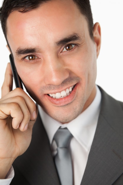Feche acima do empresário sorridente no telefone