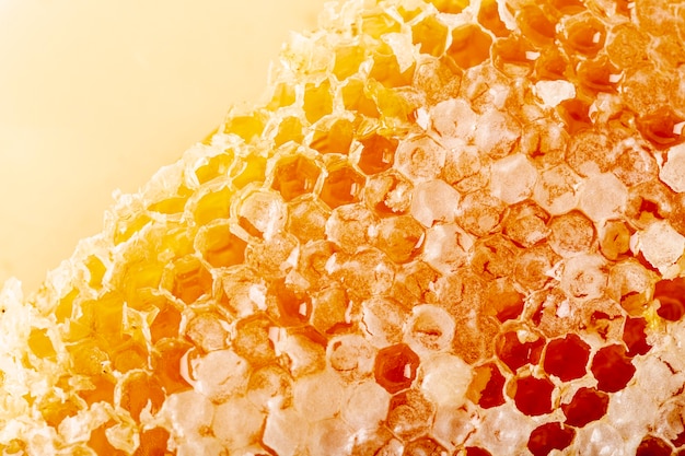 Foto feche acima do favo de mel natural dourado no mel