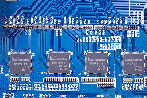 Feche acima do fundo azul eletrônico dos componentes eletrônicos de placa de circuito.