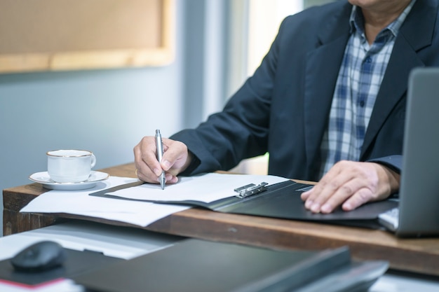 Feche acima do homem de negócios sênior que trabalha no escritório.