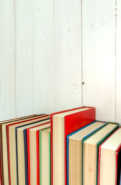 Foto feche acima do livro romance vermelho estende o fundo é uma parede de madeira branca.