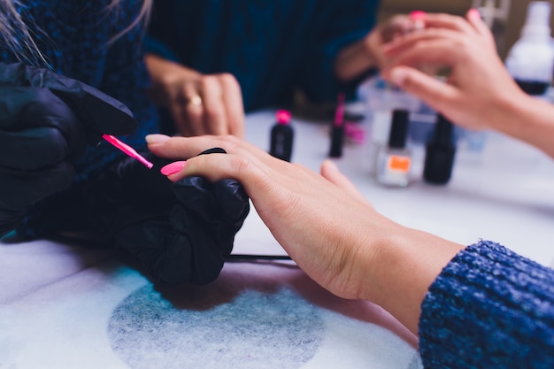 Feche acima do processo france manicure no salão de beleza.