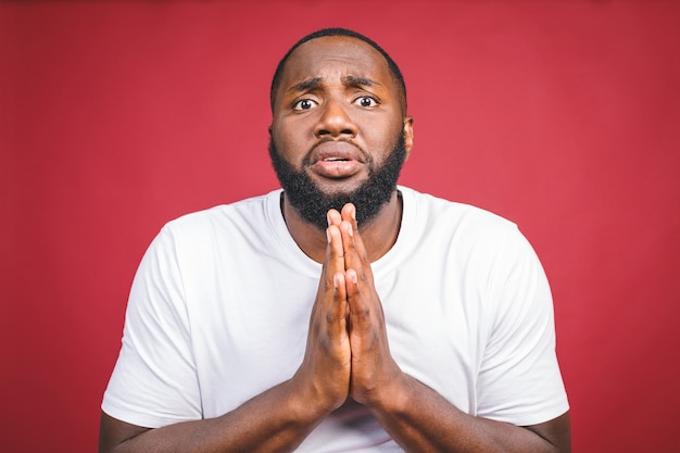 Feche acima do tiro do homem Africano vestindo camiseta branca em pé com olhar deprimido e triste, pensando em algo ruim aconteceu, esperando o melhor. Expressões e emoções do rosto humano