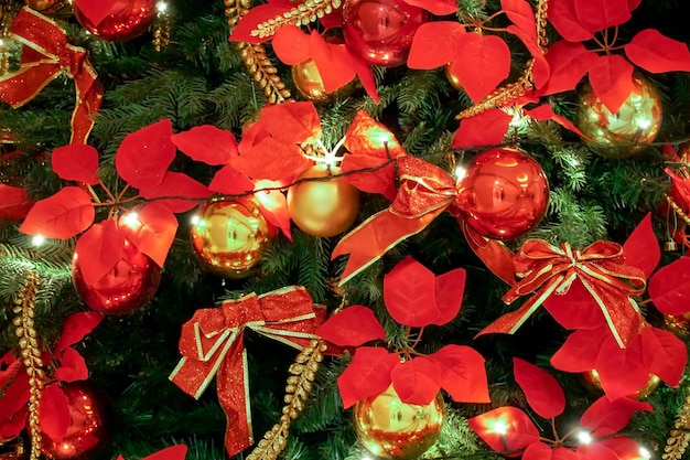 Feche as decorações de Natal vermelhas e douradas na árvore de Natal