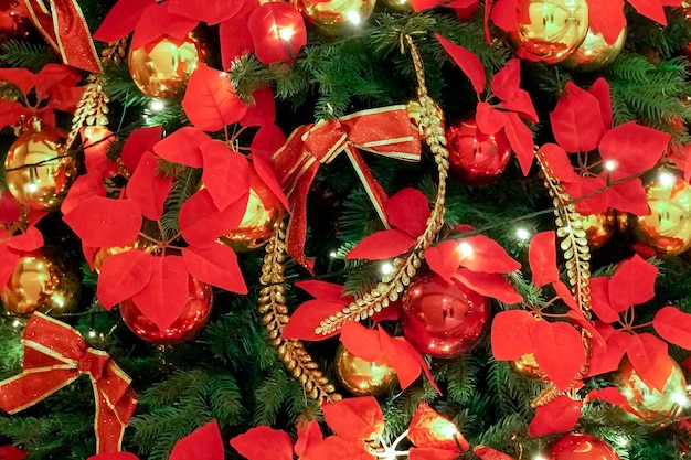 Feche as decorações de Natal vermelhas e douradas na árvore de Natal