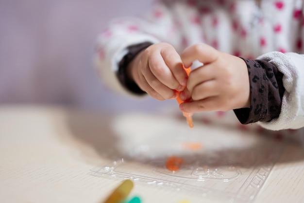 Feche as mãos da arte de decoração de menina com tubo de tinta de decoração brilhante