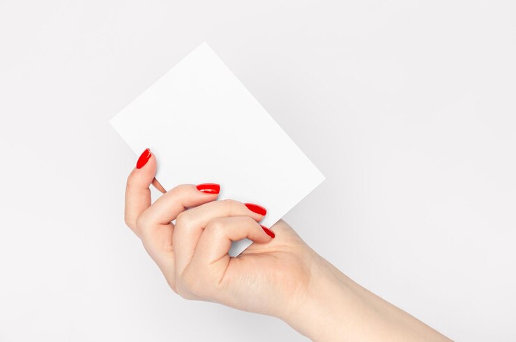 Foto feche as mãos da mulher com unhas vermelhas segurando uma folha de papel em branco em um espaço de cópia de fundo branco