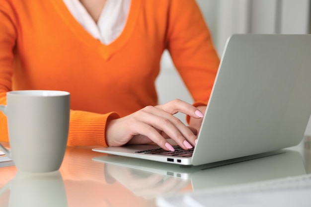 Feche as mãos da mulher de negócios digitando no computador portátil