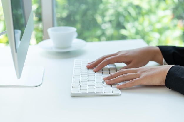 Feche as mãos das mulheres com teclado de computador