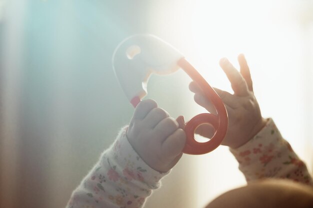 Feche as mãos do bebê segurando o brinquedo