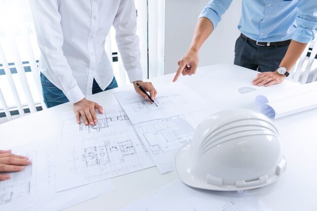 Feche as mãos do engenheiro discutindo um projeto de construção do prédio no local de trabalho