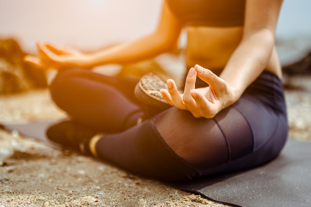 Foto feche as mãos. mulher fazer ioga ao ar livre. conceito de ioga e saudável. lotus pose. fundo de welness.