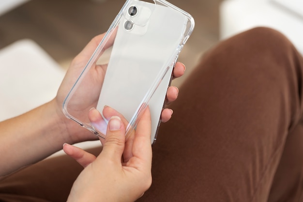 Foto feche as mãos segurando a capa e o telefone