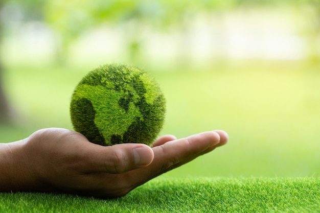 Feche as mãos segurando a terra no fundo verde, proteja a natureza e salve a terra