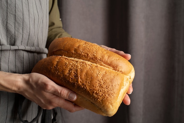 Foto feche as mãos segurando um pão