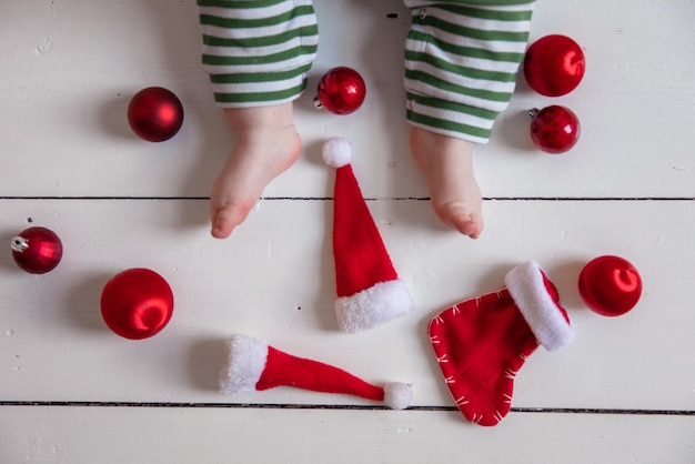 Feche as pernas de uma criança com decorações de natal vermelhas flatlay de natal