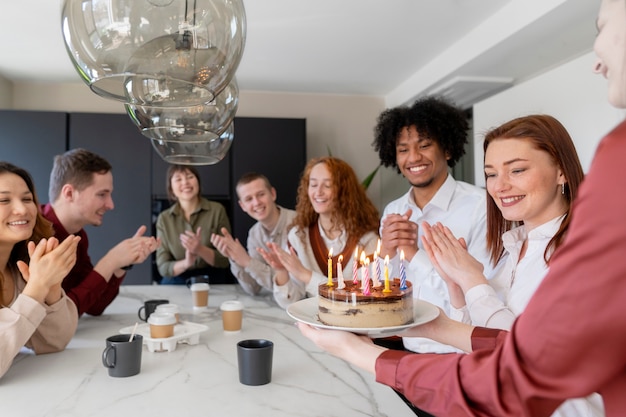 Feche as pessoas comemorando aniversário no trabalho