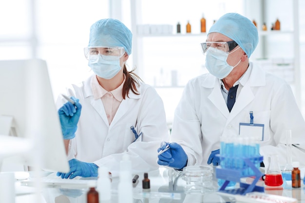 Feche cientistas usando um computador em um laboratório médico