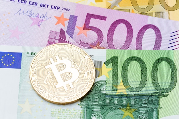 Feche de bitcoins dourados sobre fundo de moeda euro. Foto de alta resolução.