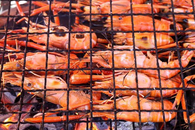 Feche de camarão grelhado em um fogão a carvão quente na festa no acampamento.