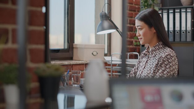 Feche de empresário trabalhando no design de projetos de negócios com computador. Mulher planejando estratégia de marketing e gestão para desenvolvimento no escritório de inicialização. Pessoa fazendo trabalho de análise