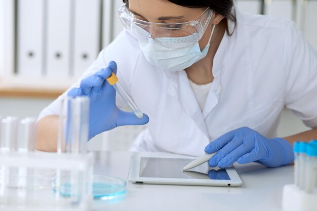 Feche de mãos de pesquisa científica com solução clara em laboratório.