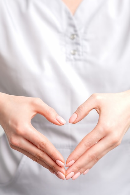 Foto feche de mãos femininas fazendo formato de coração. conceito romântico.