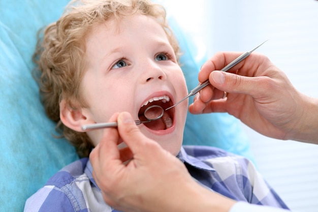 Feche de menino tendo seus dentes examinados por um dentista.