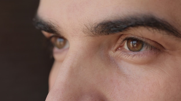 Foto feche de rosto masculino. homem atraente com olhos castanhos e cílios longos.