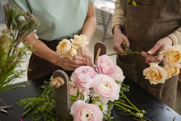 Feche de uma bela composição de flores com rosas e peônias na mesa da floricultura, copie o espaço