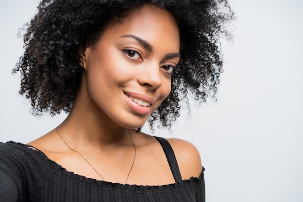 Feche o auto-retrato de uma linda mulher afro-americana, tirando uma selfie.