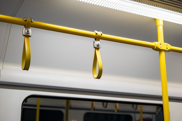 Feche o cabo de borracha - plástico segurando a mão no trem de ligação do trilho de ariport.