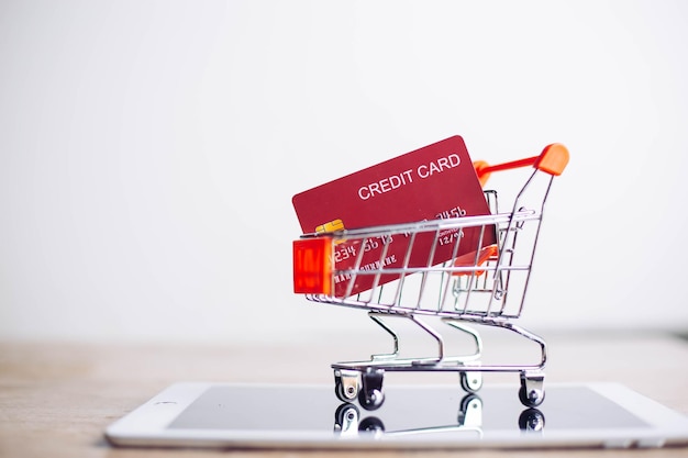 Foto feche o cartão de crédito plástico colocado em um carrinho de compras conceito de compras online